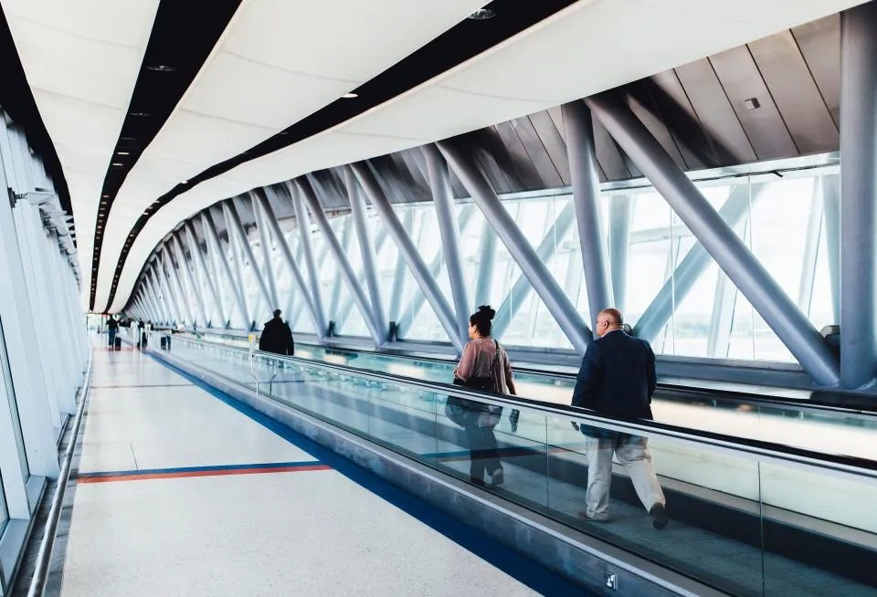 Travellers on a moving walkway at an airport